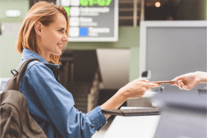 Passport Delivery Service - a woman handing her passport to an attendant at airport checkin